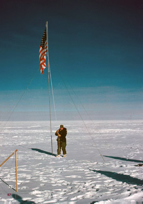 Tourist raising a flag at the actual pole